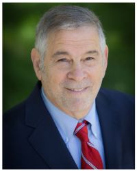 Headshot of Michael Berenbaum in red tie and blue shirt and jacket